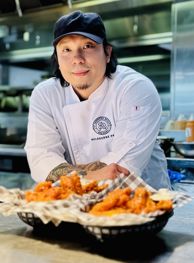 Smiling chef behind delicious stadium food