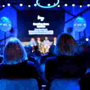 Two people at a Levy conference watching the stage
