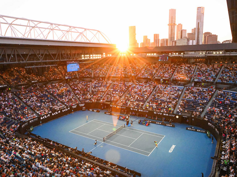 Tennis match on iconic Australian Open blue courts with light seeping in