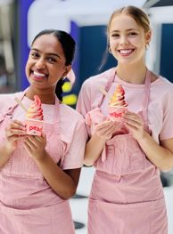 Two smiling front of house team members holding Peach Melbourne frozen yogurt