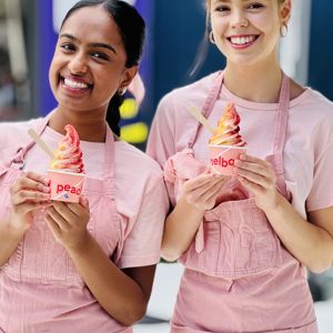 Two smiling front of house team members holding Peach Melbourne frozen yogurt