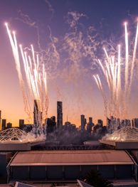 Fireworks over Melbourne Park stadium at dusk